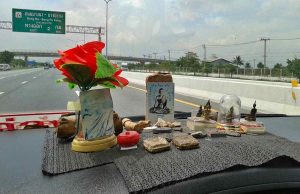 Buddhist Amulets on a car dashboard in Thailand