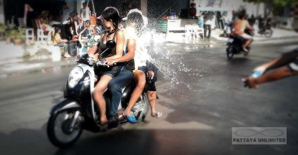 Motorcyclists getting splashed with water during theThailand Songkran Festival
