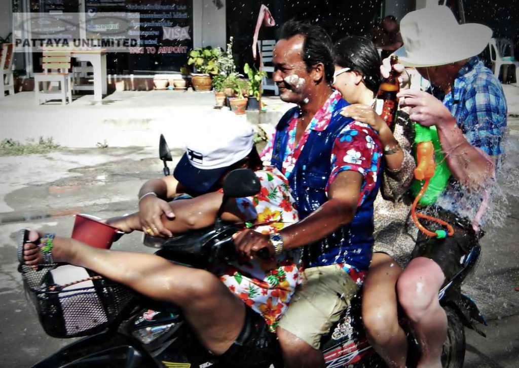 four revelers on a motorcycle during songkran in Thailand