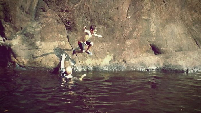 Young boy jumping into the pool at Klong Plu waterfall Koh Chang
