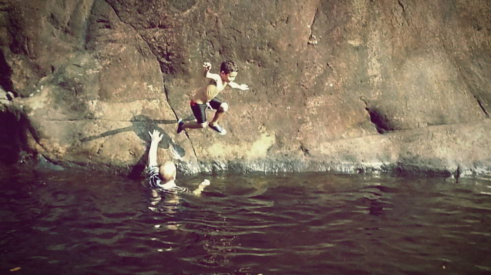 A young child jumping into the plunge pool at Klong Plu waterfall, Koh Chang