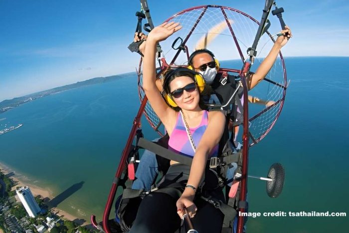 Passenger and pilot mid-flight on a tandem paramotor flight in Pattaya