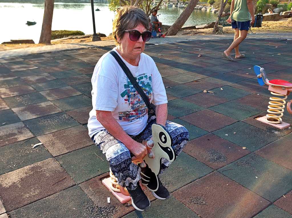 Foreign granny testing the playground rides in Nongprue Park, Pattaya